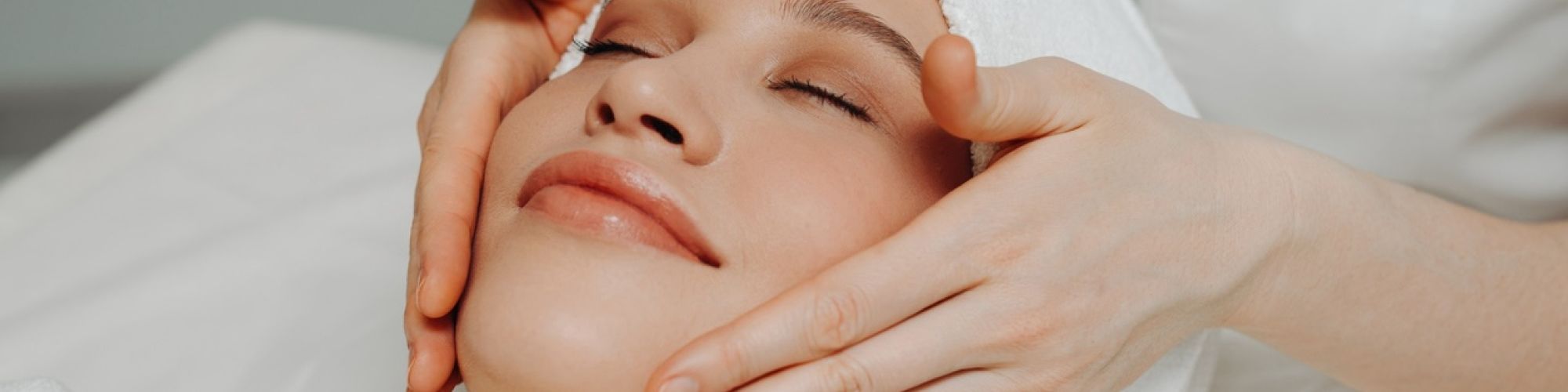 Happy woman getting facial at spa.